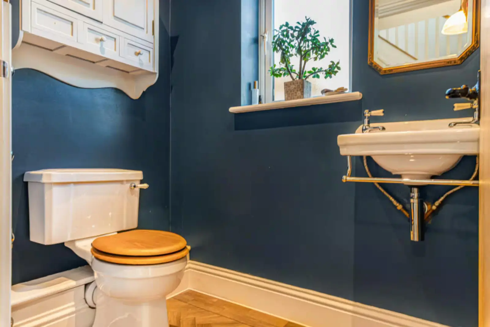 Bromley Retreat cloakroom with deep blue walls and brass details